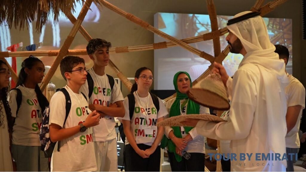 Emirati guide leading young participants in a traditional activity during the Operation Smile UAE cultural tour in Abu Dhabi